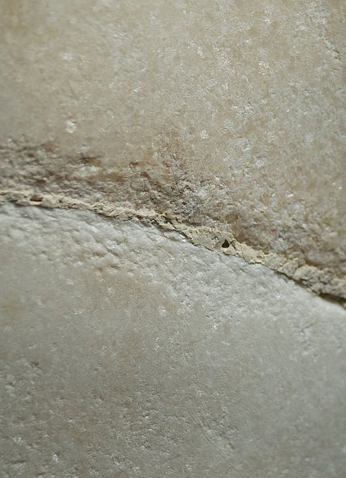 Roman Art | Online Scholarly Catalogue | Art Institute of Chicago | Detail showing the adhesive between the original body and the restored leg of Fragment of a Portrait Statue of a Man (2nd century A.D.).